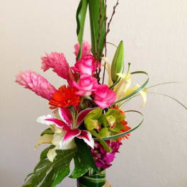 Tall tropical bouquet with pink and white flowers in a wrapped vase