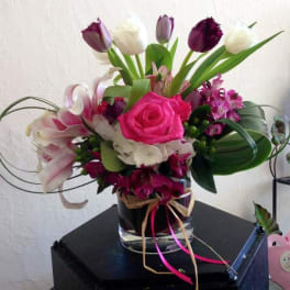 Pink rose and mixed flower arrangement in a glass vase