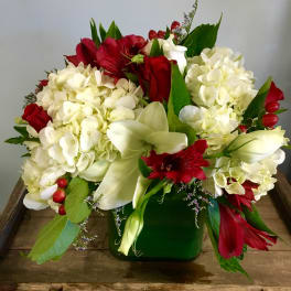 Red and white floral arrangement in a green vase
