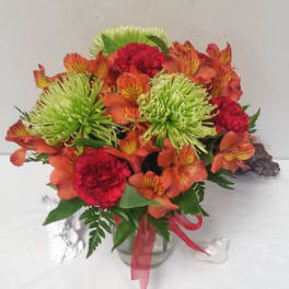 Bouquet of orange alstroemeria and red carnations in a glass vase