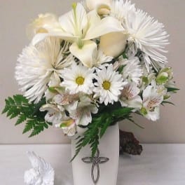 White floral arrangement in a tall vase with an angel figurine