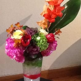 Colorful floral arrangement in a clear vase with orange and pink blooms