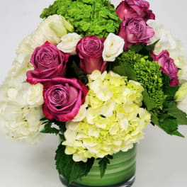 Bouquet of pink roses and white hydrangeas in a green glass vase