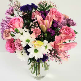 Pink and purple mixed bouquet in a clear glass vase
