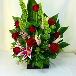 Red roses and pink lilies in a black rectangular vase