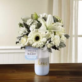 White floral bouquet in a vase with a "Sweet New Baby" tag