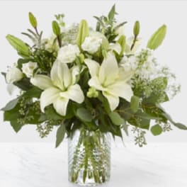 White lilies and roses in a clear glass vase