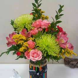 Colorful bouquet of pink and green flowers in a pencil-decorated vase