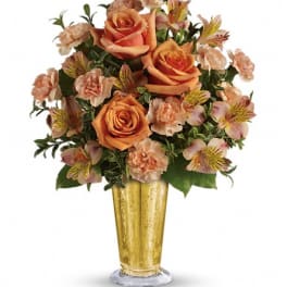 Orange roses and peach flowers in a gold vase