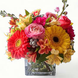 Colorful mixed bouquet in a square glass vase