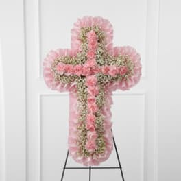 Pink floral cross-shaped standing spray on an easel