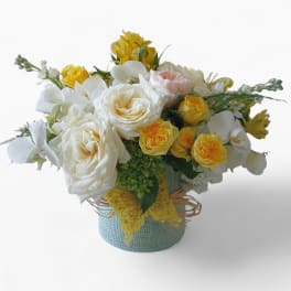 Bouquet of white and yellow roses in a blue textured vase
