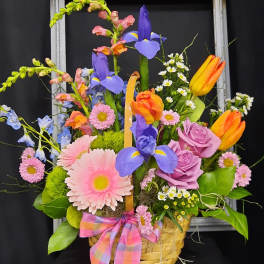 Colorful mixed flower basket with tulips, roses, irises, and daisies