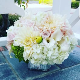 White and blush floral arrangement in a clear glass vase