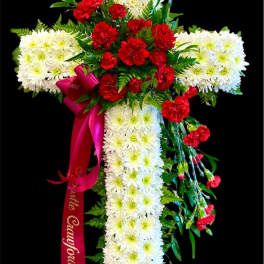 Cross-shaped floral tribute with white chrysanthemums and red carnations