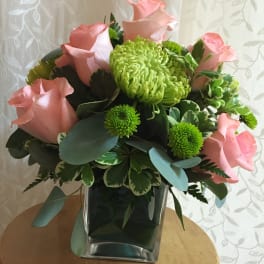 Pink roses and green chrysanthemums in a square glass vase