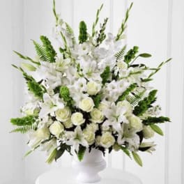White floral arrangement in a white pedestal vase