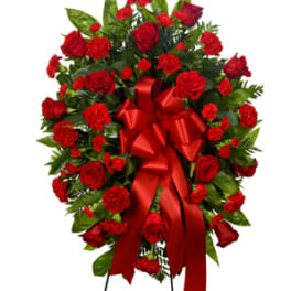 Standing spray of red roses and carnations with a red ribbon bow