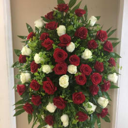 Standing spray of red and white roses with greenery
