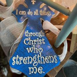 Blue cross-shaped ornament with a Christian quote