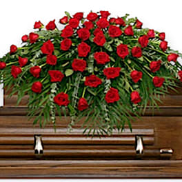 Red rose casket spray on a wooden coffin