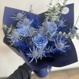 Blue rose bouquet with spiky thistle-like blooms and dark wrapping