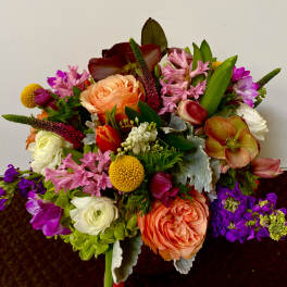 Colorful mixed bouquet with peach roses, pink blooms, and purple flowers