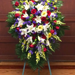 Standing funeral spray with red, white, yellow, and purple flowers