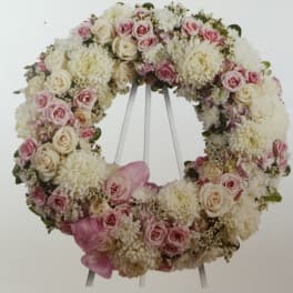 Pink and white floral wreath on a stand