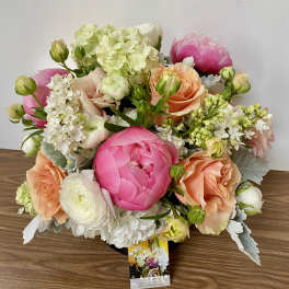 Bouquet of pink, peach, and white flowers in a low arrangement