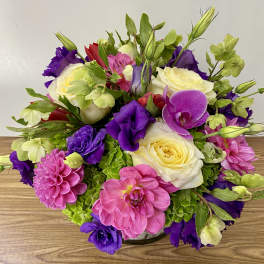Bouquet of pink, purple, and white flowers in a low vase