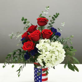 Red roses and white hydrangeas in a patriotic flag-wrapped vase