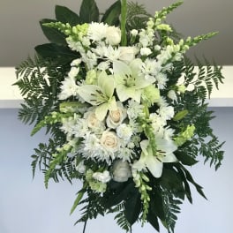 White floral standing spray with lilies, roses, and chrysanthemums