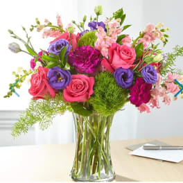 Bouquet of pink and purple flowers in a clear glass vase