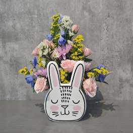 Mixed pastel flowers arranged in a bunny-shaped container