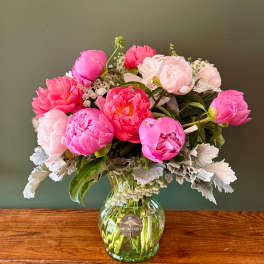 Pink and blush peonies arranged in a glass vase