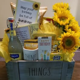 Gift basket with sunflowers, cards, candy, and a bottle of lemonade