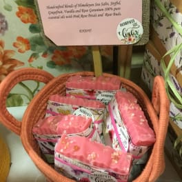 Basket of pink handmade soaps with floral packaging