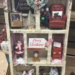 Miniature Christmas room display with Santa, a chair, and holiday decor