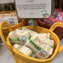 Basket of handmade soap bars with a product sign