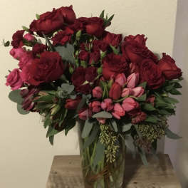 Bouquet of red and pink roses in a clear glass vase