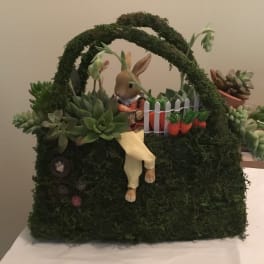 Succulent-filled basket with a rabbit figurine and small fence