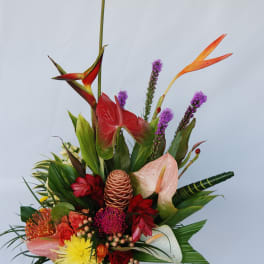 Tropical flower arrangement in a red vase with anthuriums and orchids