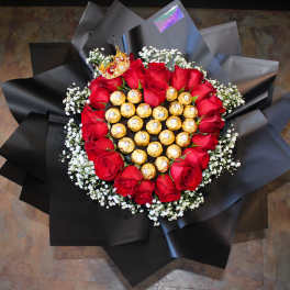 Heart-shaped bouquet of red roses with chocolates in black wrap