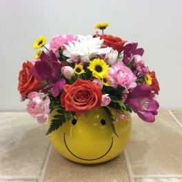 Mixed bouquet in a yellow smiley-face container