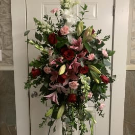 Standing floral spray with red roses, pink lilies, and white snapdragons