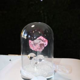 Pink crystal rose under a glass dome with a ribbon base