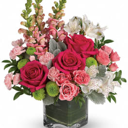 Pink and white mixed flower arrangement in a square glass vase
