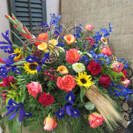 Colorful mixed flower arrangement with roses, irises, sunflowers, and calla lilies