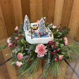 Winter floral arrangement with a miniature ice rink scene and pink flowers